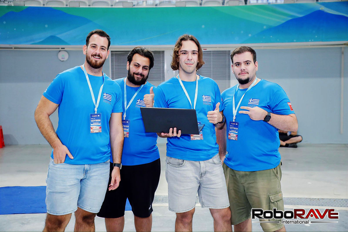 Πορτρέτο των τεσσάρων μελών της ομάδας Roboheads με μπλε μπλούζες με σήματα της ελληνικής σημαίας και κορδέλες της διοργάνωσης, με ένα από αυτά να κρατά φορητό υπολογιστή.